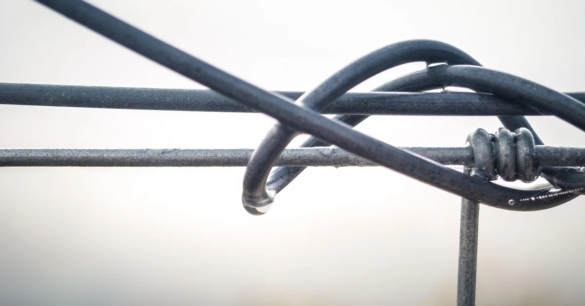 Close-up of twisted metal wires with knots, illustrating the danger of wire exposure.