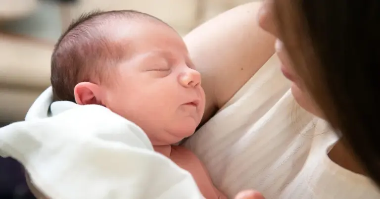 Newborn baby cradled in a parent's arms shortly after birth