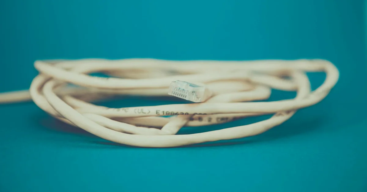 A close-up view of a tangled electrical cable on a blue background.