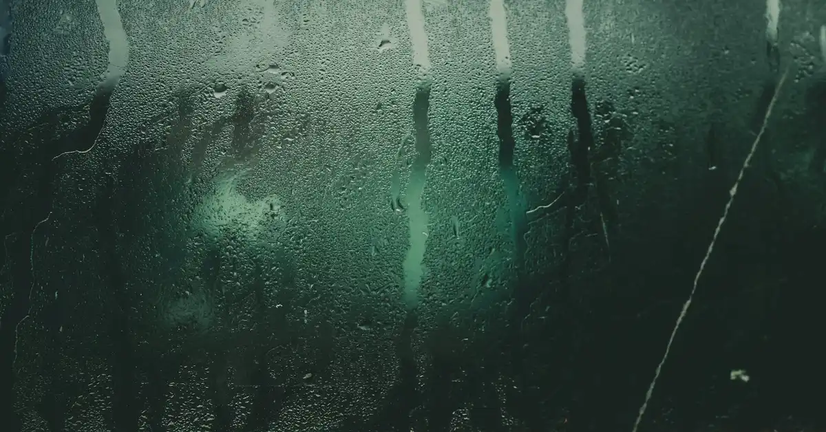 Condensation on a glass aquarium window with droplets, illustrating ventilation concerns