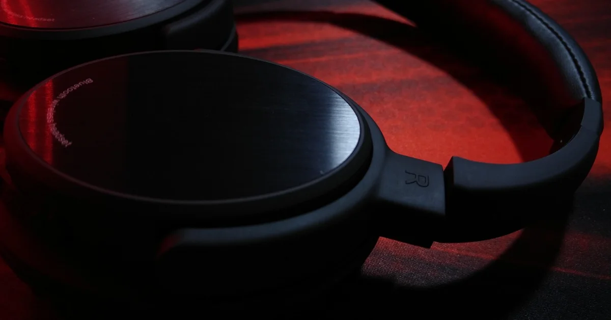Close-up of black over-ear headphones resting on a red surface