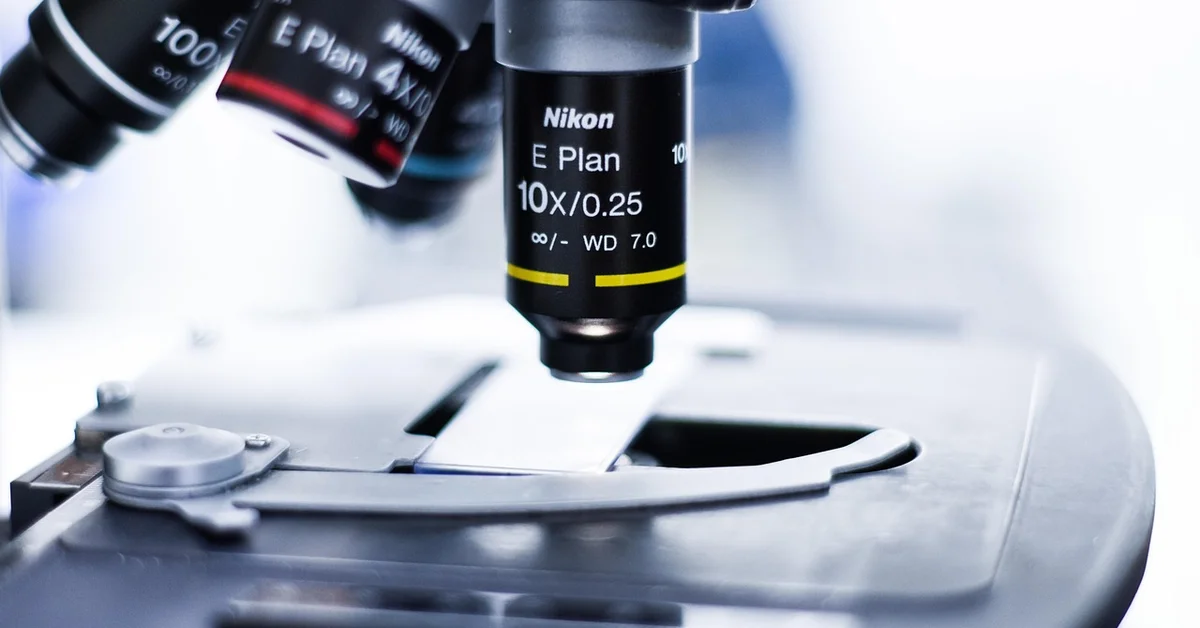 Close-up of a microscope objective lens in a laboratory, symbolizing scientific research involving lab mice