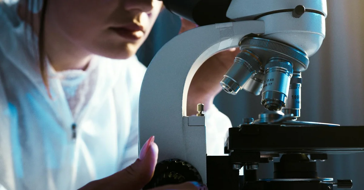 Scientist examining a specimen under a microscope
