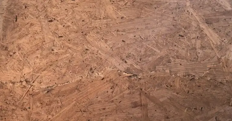 A surface of wood composite with noticeable chew marks, indicating rodent activity.