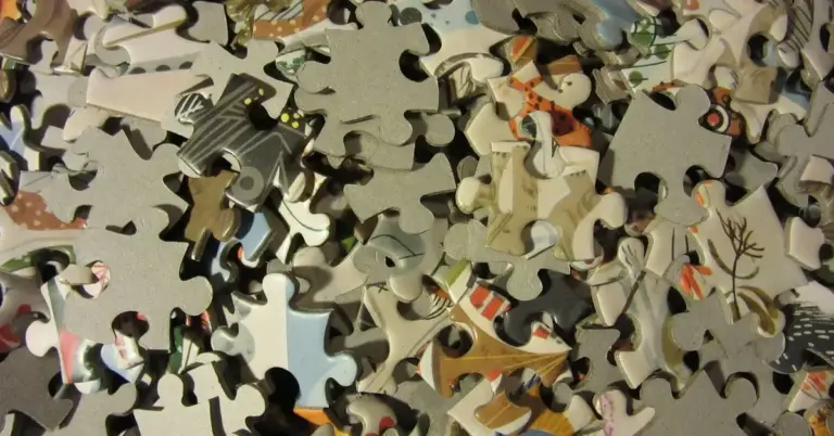 Close-up of scattered jigsaw puzzle pieces in various colors and patterns, representing the complexity of DIY foraging puzzles for mice.
