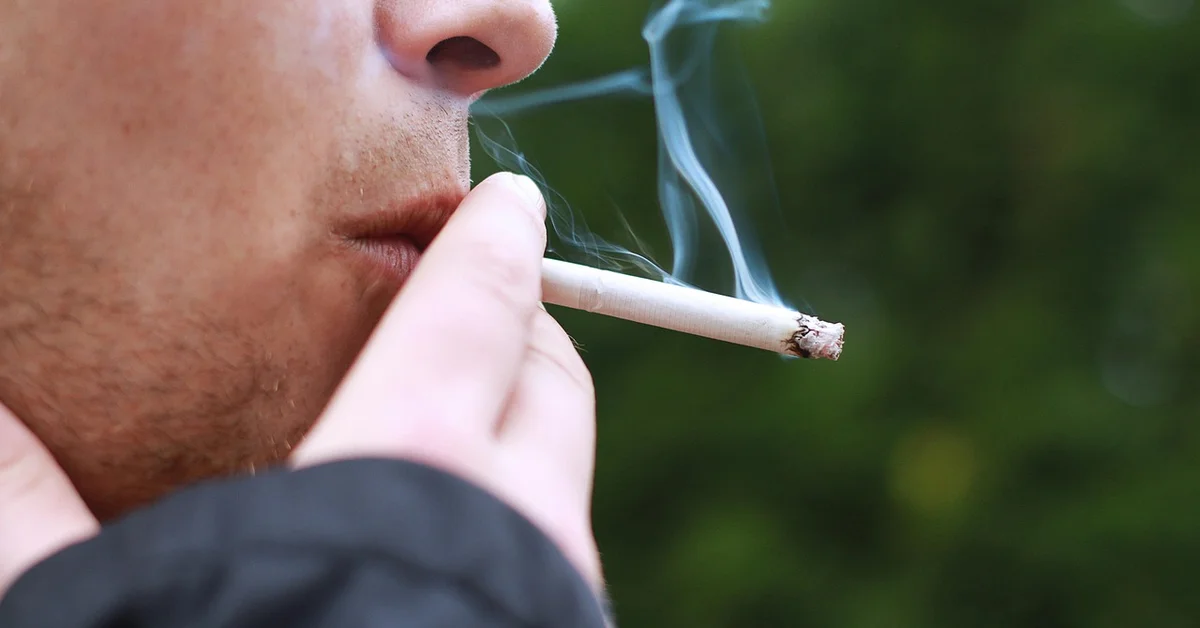 Close-up of a person smoking a cigarette outdoors