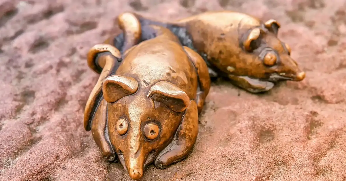 Sculpted mice lying side by side on a textured red surface