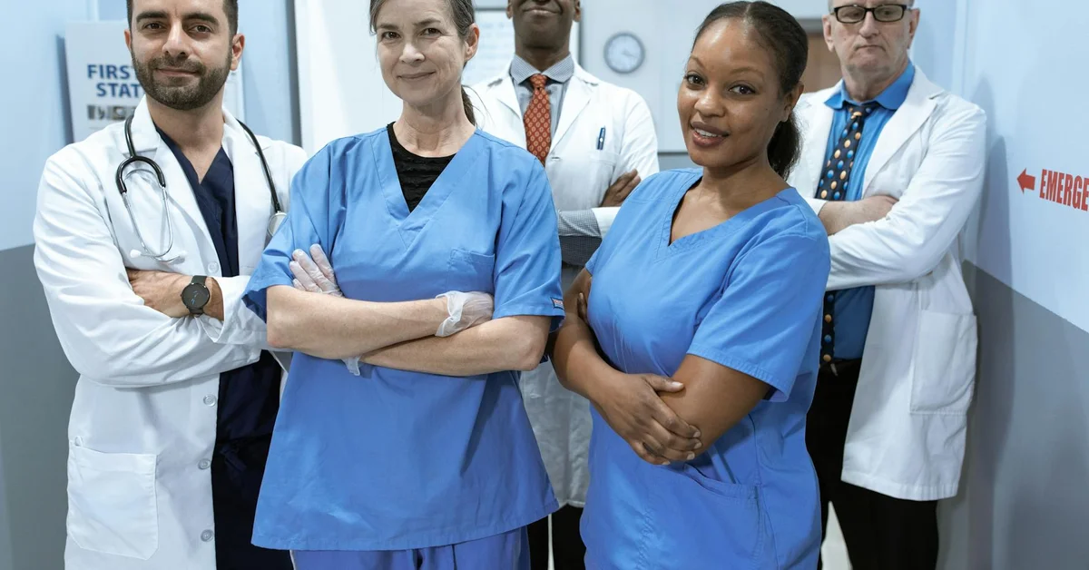 A diverse group of veterinarians in scrubs standing confidently in a clinic.